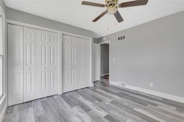 1301 Bechtel St, Monaca, PA 15061 - unfurnished bedroom featuring multiple closets, wood finished floors, and a ceiling fan