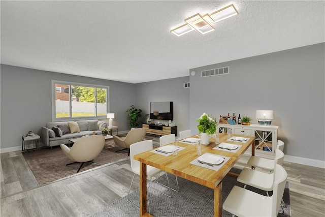 1301 Bechtel St, Monaca, PA 15061 - dining room featuring light wood-style flooring and a textured ceiling