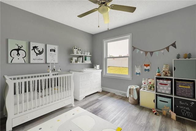 1301 Bechtel St, Monaca, PA 15061 - bedroom featuring a nursery area, wood finished floors, and a ceiling fan
