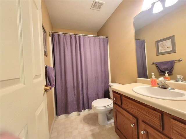 bathroom with vanity, toilet, and curtained shower