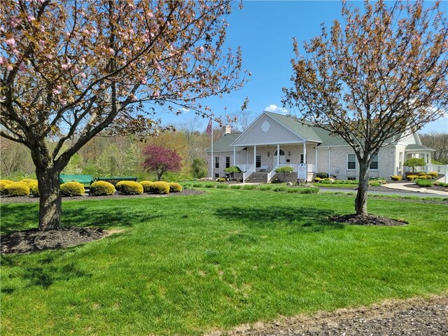 view of front of property with covered porch and a front lawn