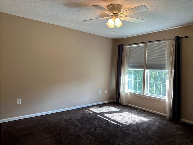 spare room with dark colored carpet, a textured ceiling, baseboards, and a ceiling fan