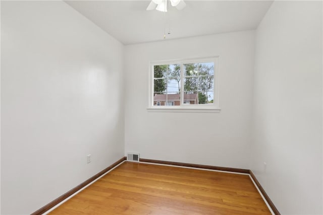 empty room featuring light wood-style floors, baseboards, and a ceiling fan