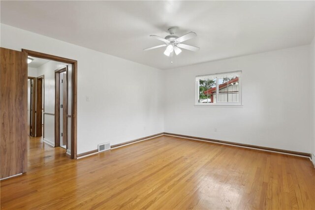 empty room featuring a ceiling fan, light wood-style flooring, and baseboards