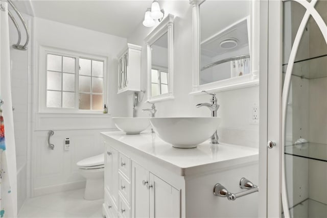 bathroom with toilet and double vanity