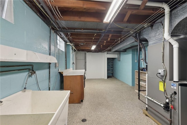 unfinished below grade area featuring concrete block wall and heating unit