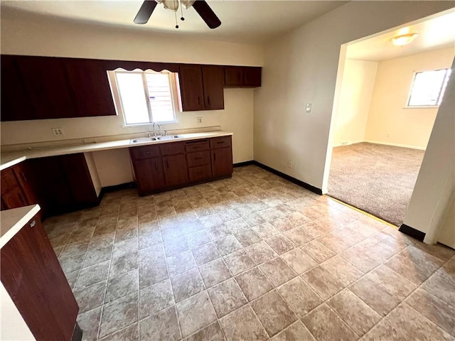 1244 Maple Ave, Monessen, PA 15062 - kitchen with a ceiling fan, a sink, light countertops, baseboards, and dark brown cabinets