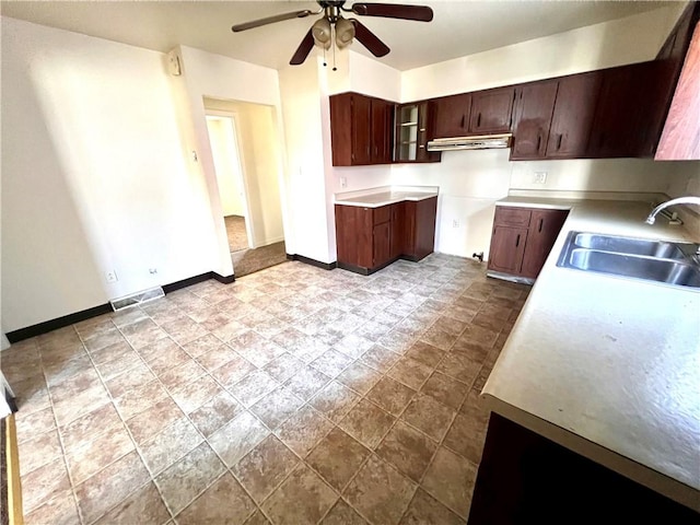 1244 Maple Ave, Monessen, PA 15062 - kitchen with a sink, a ceiling fan, baseboards, under cabinet range hood, and dark stone finish floors