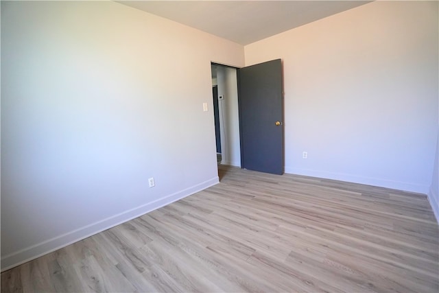spare room with light wood finished floors and baseboards