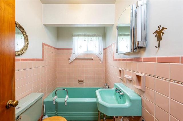 642 Washington St, Fairfield Twp, PA 15923 - full bath featuring tile walls, a sink, a bath, a wainscoted wall, and toilet
