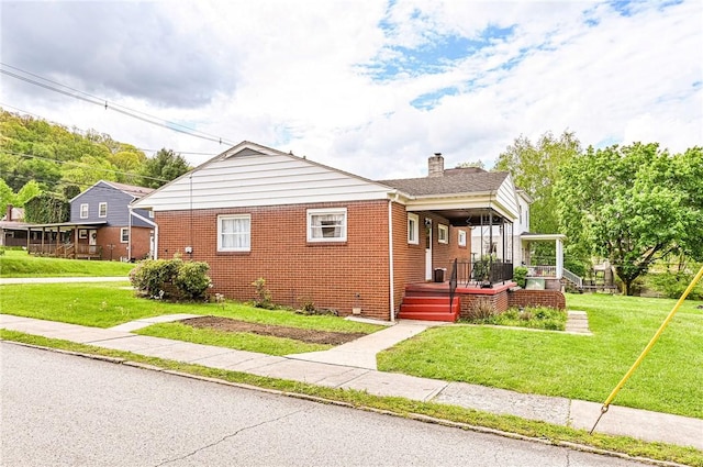 642 Washington St, Fairfield Twp, PA 15923 - bungalow-style home with a chimney, brick siding, and a front lawn