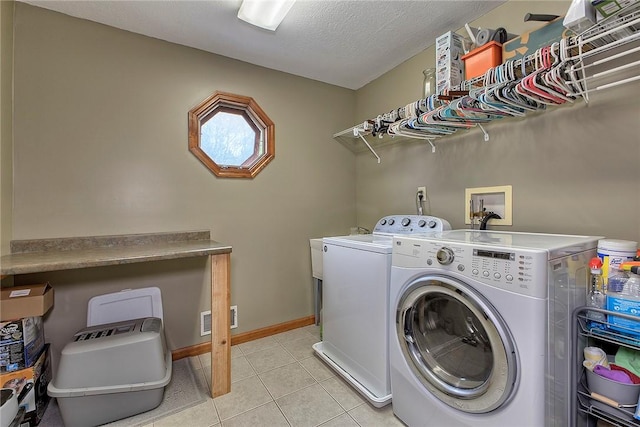 1057 Finchley Rd, North Huntingdon, PA 15642 - washroom with washer and clothes dryer, light tile patterned flooring, baseboards, and a textured ceiling