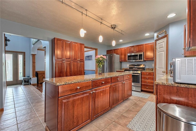 1057 Finchley Rd, North Huntingdon, PA 15642 - kitchen featuring appliances with stainless steel finishes, a kitchen island, light tile patterned floors, light stone countertops, and recessed lighting
