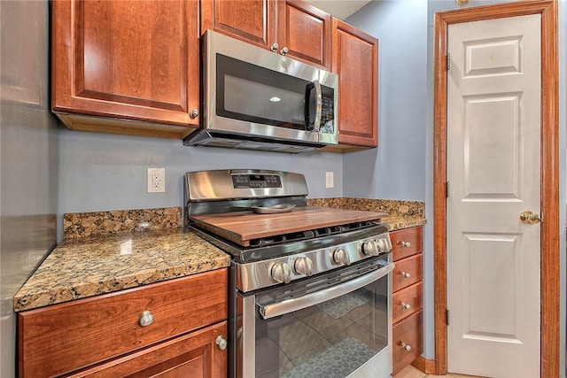 1057 Finchley Rd, North Huntingdon, PA 15642 - kitchen featuring appliances with stainless steel finishes, light stone countertops, and brown cabinets