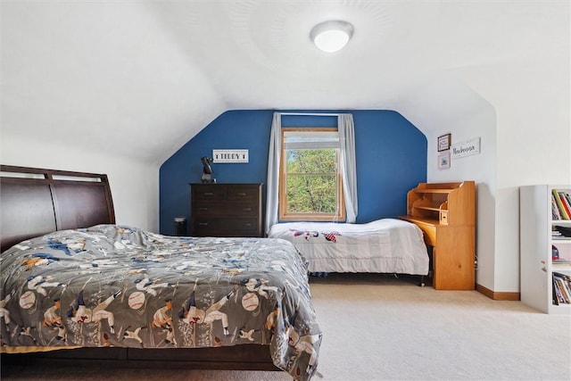 carpeted bedroom featuring lofted ceiling and baseboards