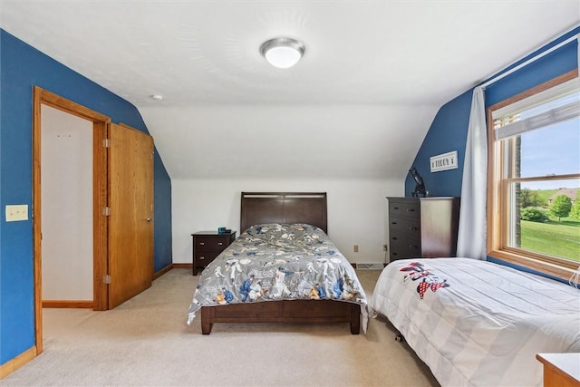 carpeted bedroom featuring lofted ceiling and baseboards