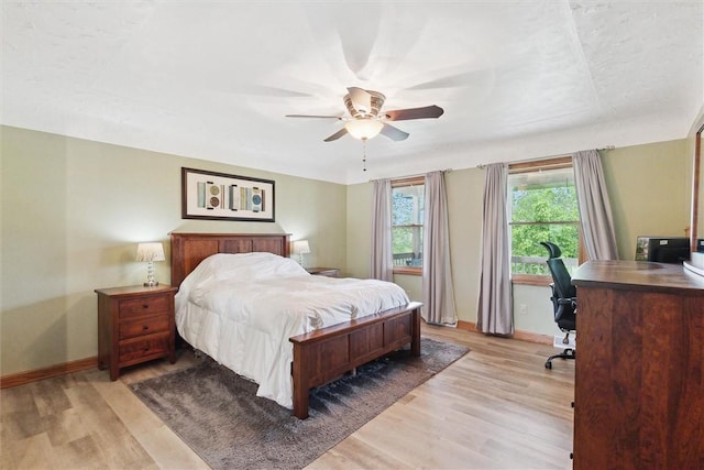 bedroom featuring baseboards, a desk, and light wood finished floors