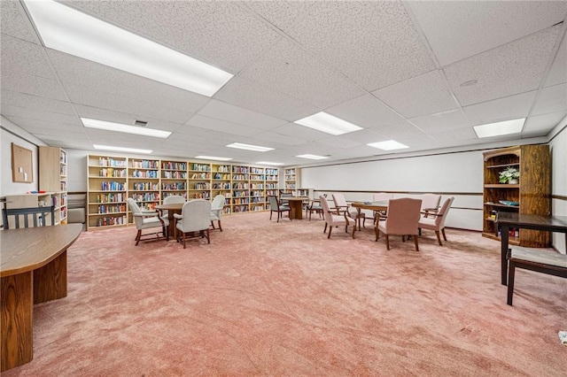 dining area with a drop ceiling and carpet floors