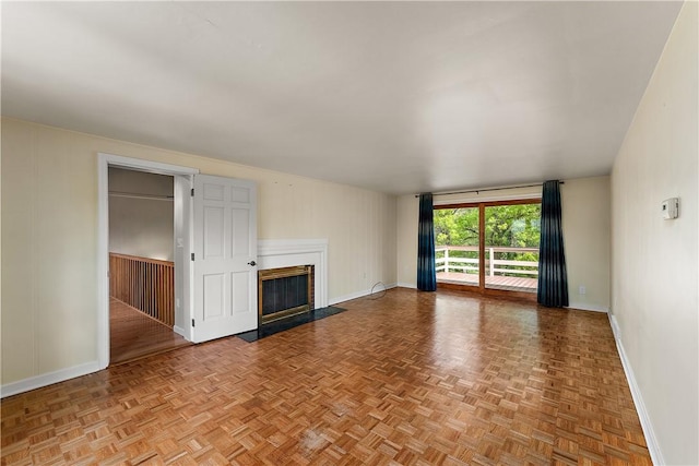 unfurnished living room featuring baseboards and a glass covered fireplace