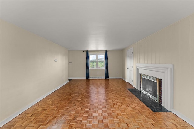 unfurnished living room featuring baseboards and a fireplace