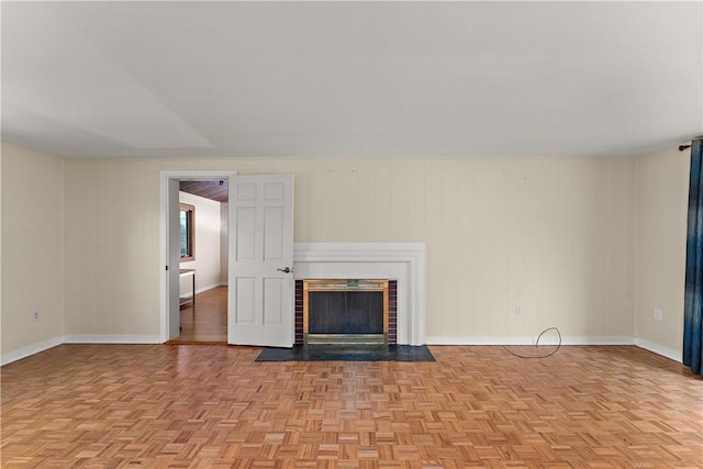 unfurnished living room featuring baseboards and a brick fireplace