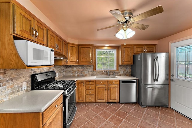 kitchen featuring appliances with stainless steel finishes, brown cabinetry, and light countertops