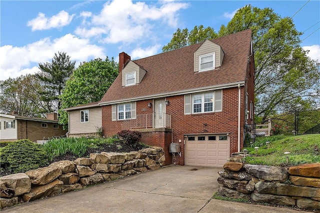 cape cod house with driveway, a chimney, an attached garage, brick siding, and fence