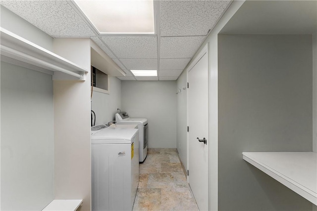 washroom featuring stone finish floors and washing machine and clothes dryer