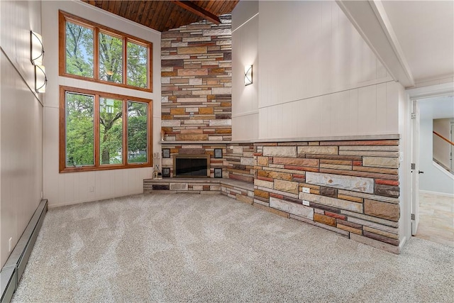 unfurnished living room with a baseboard radiator, a stone fireplace, wood ceiling, carpet, and beamed ceiling