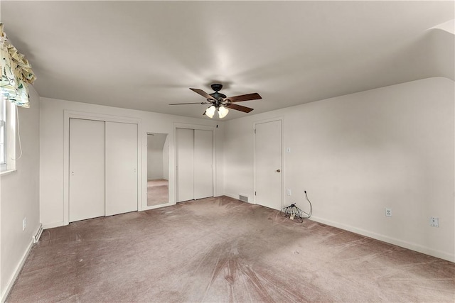 unfurnished bedroom with multiple closets, carpet, baseboards, and ceiling fan