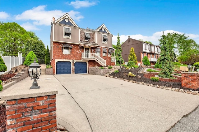 view of front of house with brick siding, fence, a garage, driveway, and stairs