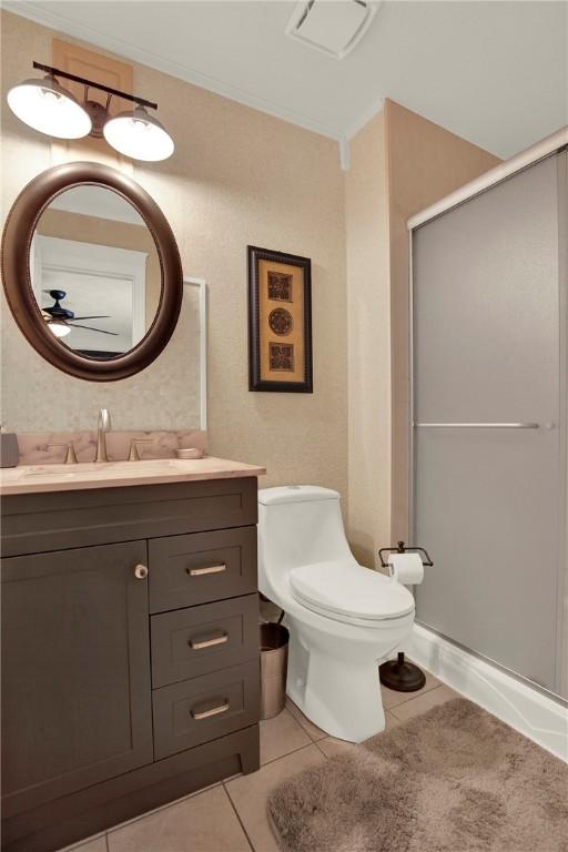 bathroom featuring tile patterned floors, vanity, ceiling fan, toilet, and a shower with shower door