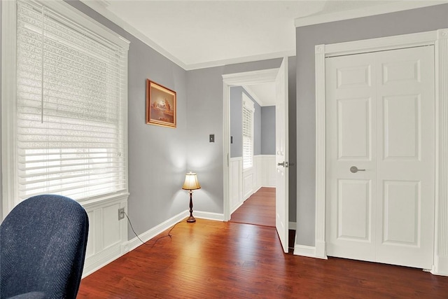 office space with dark wood-style floors, wainscoting, baseboards, and crown molding