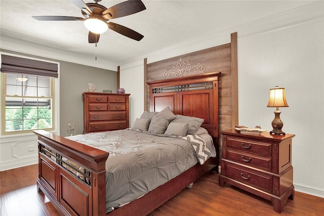 bedroom with dark wood-style flooring, ornamental molding, and a ceiling fan