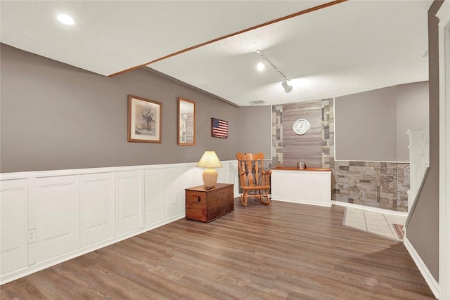 interior space with wood finished floors, a wainscoted wall, rail lighting, and recessed lighting