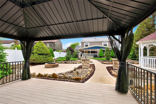 wooden terrace featuring a gazebo and an outdoor fire pit