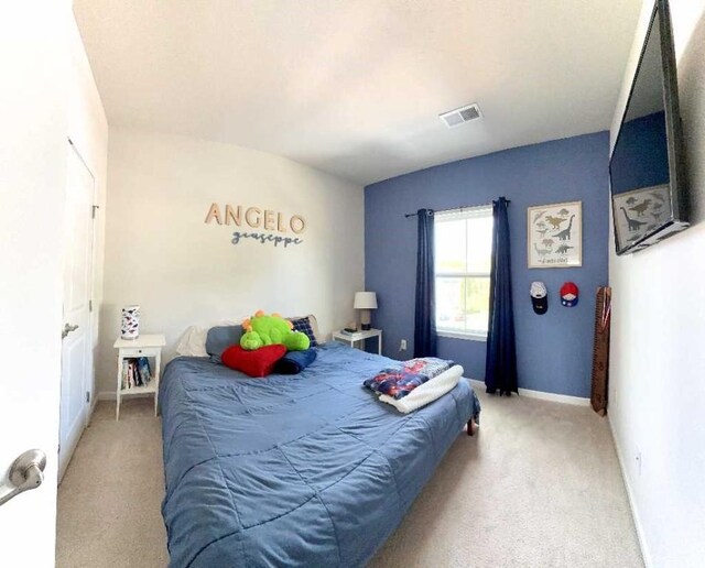 bedroom with light colored carpet and baseboards