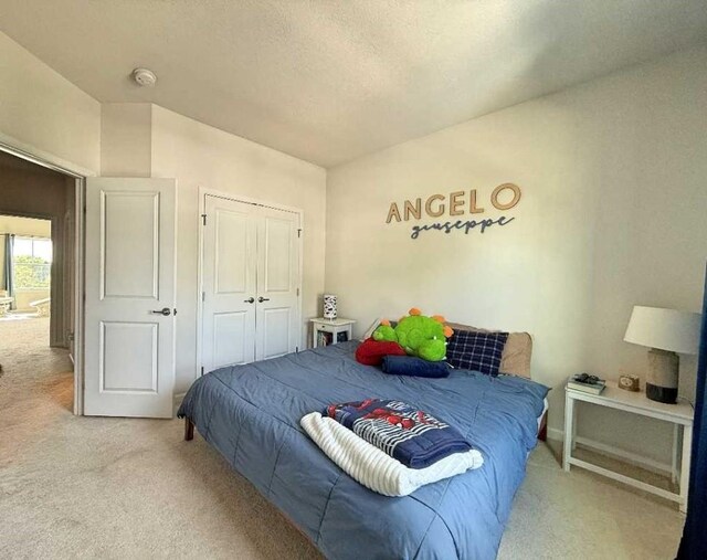 bedroom with carpet floors, a closet, a textured ceiling, and baseboards