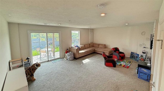 carpeted living area featuring recessed lighting and a textured ceiling