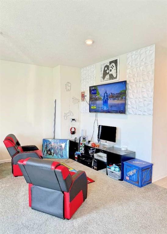 carpeted living room featuring baseboards and a textured ceiling