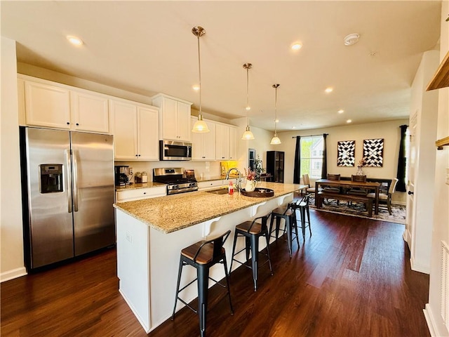 159 Cole Dr, Robinson Twp Nwa, PA 15136 - kitchen featuring appliances with stainless steel finishes, white cabinets, a sink, an island with sink, and a kitchen bar