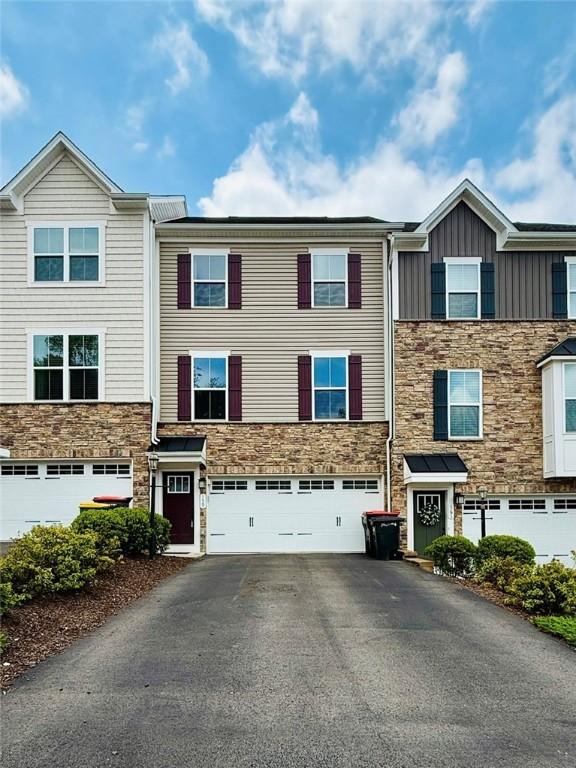 159 Cole Dr, Robinson Twp Nwa, PA 15136 - view of property featuring stone siding, asphalt driveway, an attached garage, and board and batten siding