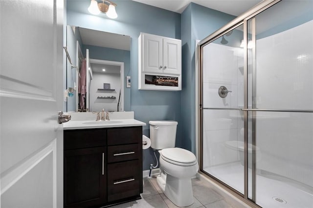 full bath with a shower stall, toilet, vanity, and tile patterned floors