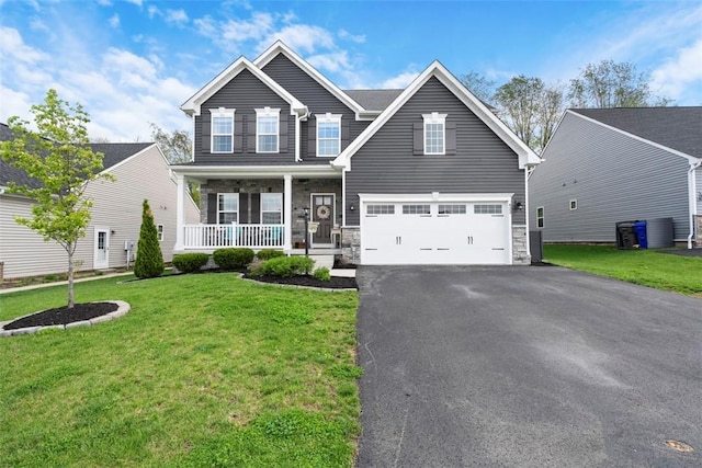 view of front facade featuring a porch, driveway, a front lawn, stone siding, and a garage