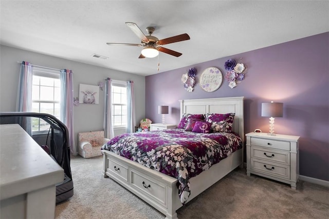 carpeted bedroom with ceiling fan and baseboards
