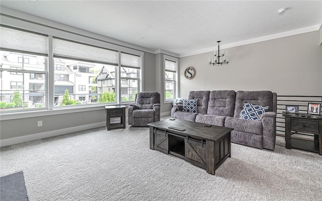 carpeted living room featuring a chandelier, ornamental molding, and baseboards