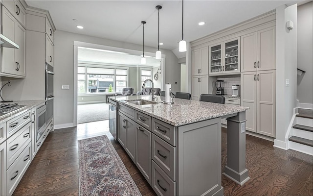 kitchen with gray cabinets, a sink, dark wood finished floors, appliances with stainless steel finishes, and recessed lighting