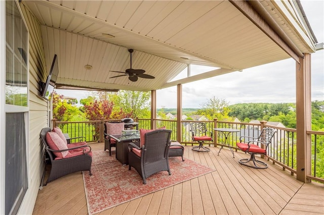 wooden terrace featuring a ceiling fan and an outdoor living space