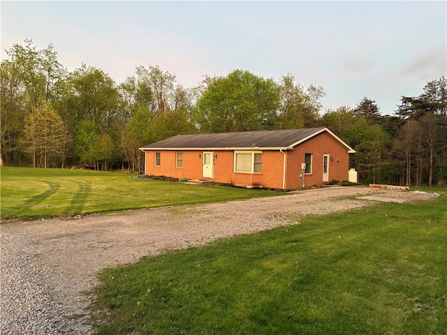 view of front of house featuring a front lawn, driveway, and brick siding