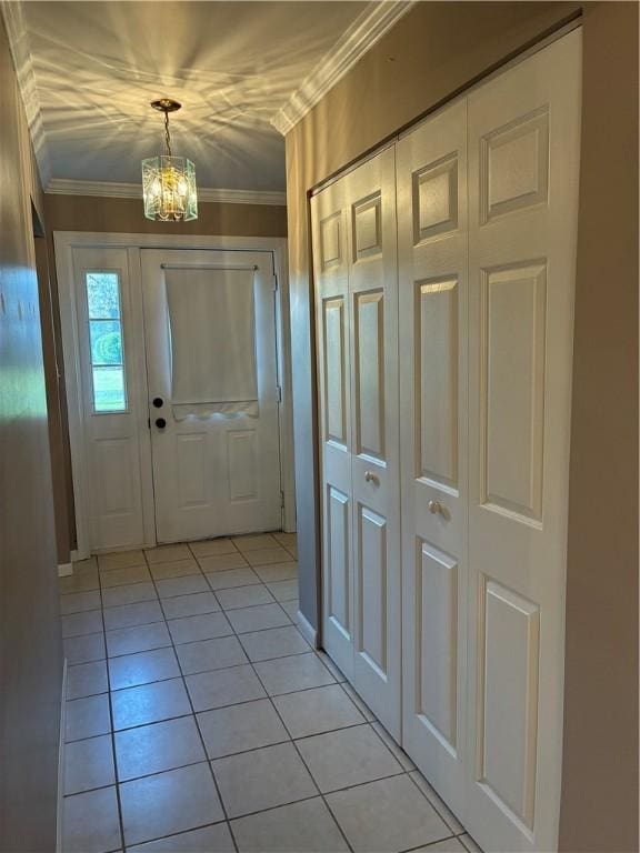 entryway featuring a chandelier, light tile patterned flooring, and ornamental molding